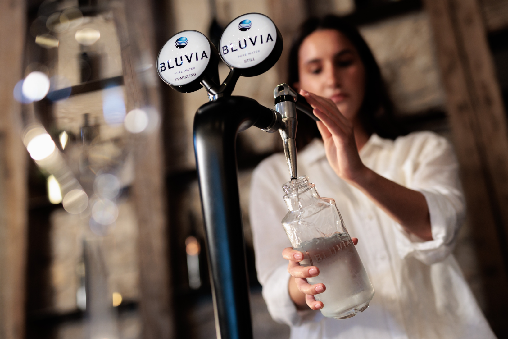 Promotional image showing waiter pouring Bluvia water